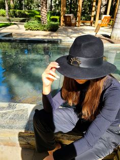 Introducing the Venice Hat, a timeless classic fedora adorned with a sleek black leather band and our iconic sun logo. This versatile accessory exudes sophistication and effortless style, making it perfect for any occasion. Whether you're exploring the canals of Venice or attending a casual city outing, this hat seamlessly complements your outfit and ensures you make a fashionable statement. Black Fedora Felt Hat For Travel, Chic Black Fedora With Flat Crown, Black Wide Brim Felt Travel Hat, Luxury Felt Fedora Hat, Elegant Black Fedora For Travel, Luxury Black Adjustable Hats, Luxury Black Wide Brim Fedora, Black Classic Felt Hat For Travel, Luxury Black Fedora With Short Brim