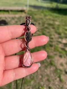 Wire wrapped Moldavite and Rhodochrosite pendant in oxidized copper wire 🤍 This beautiful piece was hand picked, made with love💗 Moldavite is the ultimate stone of transformation. It is a tektite. Known for bringing about shifts in energy, encouraging us to face negative thoughts and feelings and unleashes us from past traumas so we can move forward in life stronger. 💚✨  Rhodochrosite is known to bring feelings of compassion, deeper emotional connections, and openness to love without judgment or expectations ️ Thanks for your support! 🥰 Every pendant comes with a 18' black cord adjustable clasp necklace to fit all necks 💛 Pink Wire Wrapped Copper Jewelry, Unique Handmade Rose Quartz Jewelry, Pink Wire Wrapped Copper Wire Jewelry, Pink Copper Wire Wrapped Jewelry, Handmade Pink Copper Wire Jewelry, Wire Wrapped Crystal, Wrapped Crystal, Boho Crystal, Oxidized Copper