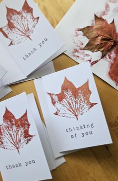 four thank you cards with red leaves on them sitting on top of a wooden table