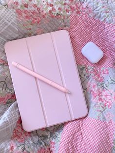 a pink tablet with a pen on top of it