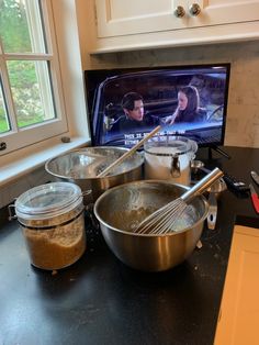 the kitchen counter is full of cooking utensils and bowls with food in them