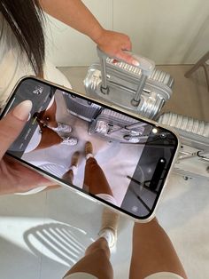 a woman is taking a selfie with her cell phone while sitting on the floor