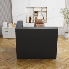 a black reception desk in an office with wooden floors and white walls, along with two planters