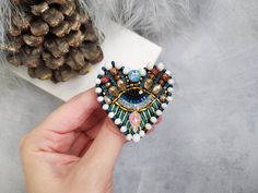 "Beautiful heart eye brooch is lovely handmade by me. 💓 This beautiful hand embroidered evil eye brooch took hours of precision and elaborate embroidery work. SIZE ~ 1,97\" x 1,97\" ( 5 cm x 5 cm) MATERIALS Made of czech seed beads and japanese seed beads, glass crystal, glass beads. Back side made of eco leather. Beaded jewelry requires careful and loving care. Avoid contact with hairspray, perfume, water, bleaches & lotions. Avoid over exposure to humidity, heat & sun. Gently wipe you Evil Heart, Leather Beaded Jewelry, Evil Eye Jewellery, Beaded Eye, Lips Pin, Eye Brooch, Heart Eye, Embroidered Brooch, Eye Gift