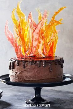 a chocolate cake with orange frosting and flames on top