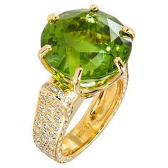 This magnificently bright green peridot ring in 18k yellow gold is an artistic wonder. The large peridot stone, cradled in a six-prong setting, is accentuated with pave-set diamonds down the sides in a cascading wall of brilliance. This trendy ring exudes presence and style and is definitely meant to be seen - subtlety need not inquire! Weight: Peridot - 20.71 carats Diamonds - 2.58 carats Peridot Jewelry, International Jewelry, Diamond Cocktail Rings, Peridot Ring, Couture Jewelry, Green Peridot, Bling Rings, Exquisite Jewelry, Jewelry Trends