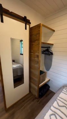 a room with a bed, mirror and closet next to the wall that has a surfboard on it