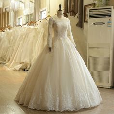 a white wedding dress is on display in a bridal room with other gowns