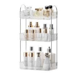 three tiered clear plastic shelf with gold and white bottles