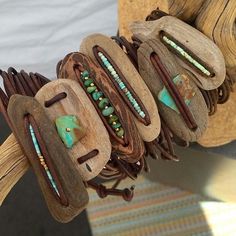 several pieces of wood with turquoise beads on them sitting on a wooden chair arm rest