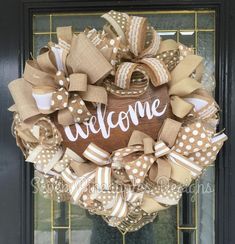 a welcome wreath hanging on the front door with burlocks and polka dot ribbon