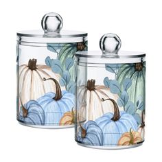 two glass canisters with painted pumpkins on them