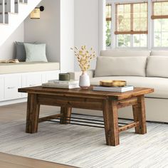 a living room with a couch, coffee table and stairs