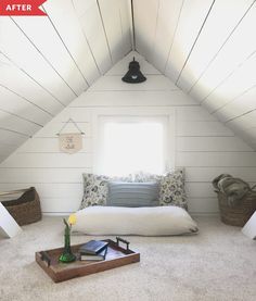 a bed sitting in the middle of a room under a slanted ceiling next to a window