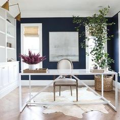 an instagram photo of a living room with dark blue walls and white furniture in the corner