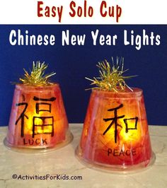 two small vases with chinese new year lights on them, each decorated in the same language