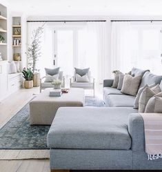 a living room filled with furniture and lots of windows