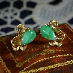 A wonderfully elegant pair of Mid-Century screw back earrings set with pear shaped jade cabochons. Hand crafted from 14ct gold, the settings feature lovely scrolled ribbons, quite Art Nouveau in style! The rich yellow tone of the gold compliments and enhances the deep green jade perfectly. The jade cabochons measure 11mm in length and the earrings weigh 3.85g in total. They are stamped 14K on the reverse of the settings. These earrings look so chic on and are very comfortable to wear. They would Art Deco Pear-shaped Jewelry For Formal Occasions, Vintage Teardrop Clip-on Earrings As Gift, Art Deco Clip-on Earrings For Anniversary, Art Deco Anniversary Clip-on Earrings, Vintage Pear-shaped Earrings For Formal Occasions, Vintage Yellow Gold Collectible Earrings, Vintage Pear-shaped Formal Earrings, Formal Pear-shaped Clip-on Earrings, Vintage Yellow Gold Teardrop Earrings