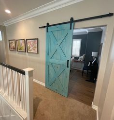 an open door leading to a living room with pictures on the wall and carpeted floor