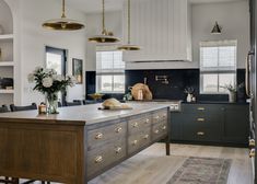 a large kitchen with an island in the middle and lots of cabinets on both sides