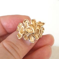 This is an absolutely amazing fancy statement gold ring. The ring is custom made and has a romantic touch into it. It is made of 10k solid yellow gold and weighs 5.5 grams. The size is 4.5 US. The ring features a gorgeous looking tropical flower where each petal is artistically crafted and different. The ends of each petal have a diamond cut, which makes the ring shine. The top of the ring measures 0.8 inches. The ring has a '10k' gold hallmark. The ring will definitely make a beautiful gift for Heirloom Nugget Rings As Gift, Gold Nugget Cluster Ring In 14k, Yellow Gold Nugget Cluster Ring For Anniversary, Unique Gold Cluster Ring For Wedding, Unique 14k Gold Cluster Ring For Anniversary, Unique Gold Jewelry For Anniversary, Heirloom Gold Nugget Ring, Unique Yellow Gold Cluster Ring For Anniversary, Unique Cluster Ring For Anniversary