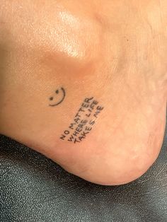 a person with a small tattoo on their foot that says smile and there is only one eye