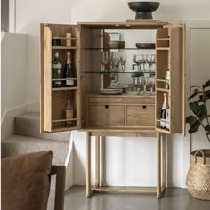 a wooden cabinet with wine glasses and bottles in it