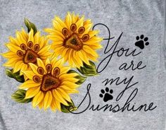 two yellow sunflowers with the words you are my sunshine written on them and paw prints