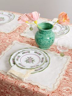 a table topped with plates and vases filled with flowers