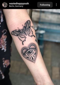 a woman's arm with an eye and butterfly tattoo on it