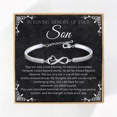 a white bracelet with an engraved message on it that says, in loving memory of your son