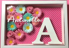 the letter a is surrounded by pink and white flowers in a shadow box with polka dots