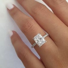 a woman's hand with a diamond ring on it and the engagement band around her finger