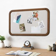 a desk with a clock, books and pictures on it