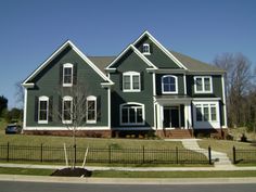 a large gray house sitting on the side of a road