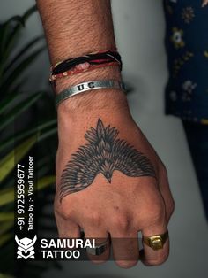 a man's hand with a bird tattoo on it