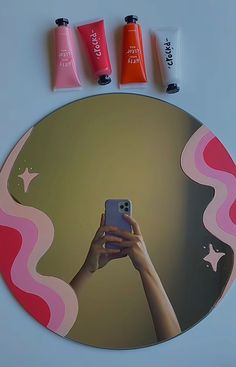 a person taking a selfie in front of a mirror with three different colors on it