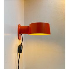 an orange wall lamp on a white wall