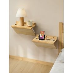 two wooden shelves with cell phones on them and a lamp in the corner next to them