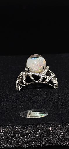 Beautiful 10mm Floating opal ring. The ring is made with only Pure Sterling Silver with beautiful patterns and a mixture of Polished Australian Opals and Kyocera opals.  The ring setting is cast in sterling silver then electroplated with rhodium to provide corrosion protection and enhance the appearance and durability of sterling silver. Gift Ready Box Included Any questions or concerns please contact us. Silver Multi-stone Opal Ring For Promise, Silver Opal Multi-stone Ring, Silver Opal Ring With Round Stone, Formal Silver Opal Cabochon Ring, Silver Opal Crystal Ring For Promise, Formal Silver Cabochon Opal Ring, Opal Crystal Ring With Accent Stones, Silver Round Opal Ring, Iridescent Opal Promise Ring