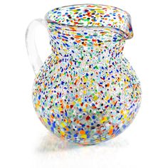 a glass pitcher with multicolored dots on it's lid and handle is shown in front of a white background