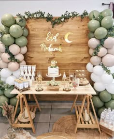 a table topped with cake and balloons in front of a wooden sign that says eat melbourne