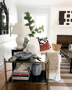 a living room filled with furniture and a lamp on top of a wooden coffee table