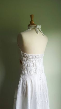 Embroidered sunflowers pop on this gorgeous white cotton-gauze dress. The lacy bodice flares into an ultra-full, handkerchief-hem skirt, with white satin ribbon accents. Easy fit, with a ruched, elasticized back and halter tie at neck. Best fits medium/large sizes. Era: 1970s Label: none ➸ visit on instagram | provenance_vintage White Ruffled Halter Neck Dress, White Halter Neck Dress With Ruffles, White Sleeveless Halter Dress For Garden Party, Bohemian Halter Dress With Smocked Back, White Fitted Bohemian Halter Dress, White Cotton Sundress With Lace Trim, White Ruffled Halter Neck Sundress, White Bohemian Sundress With Halter Neck, White Halter Neck Sundress With Ruffles