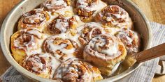 cinnamon rolls with icing in a pan on a table