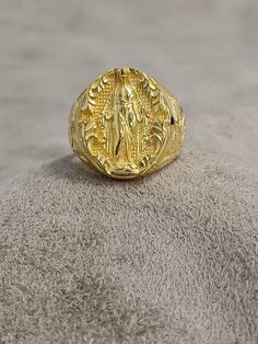 Gold Virgen Milagrosa Miraculous Ring, 10k 14k 18k Solid Gold Women's Ring, Virgen de Guadalupe Ring, Unique Gold Religious Gift for Women ★Item Details * Gender : Female / Male  * Material: 10K - 14K - 18K Gold * Ring Diameter: 1.9cm (0.8 inches)  * Ring Weight:  10K: 10.50 - 11.00 Gr 14K: 11.50 - 12.00 Gr 18K: 12.50 - 13.00 Gr * All our products are handmade and weights may vary   (-) 1,00 gram  * Ring Size: 5 US to 15 US - ( Contact me if you're expecting to buy another ring size ) * Visit our shop for more items https://www.etsy.com/shop/7SAtelier  ✔ Ready to Ship in 3-5 Business Days ✔ Free shipping worldwide! ✔ The product will be sent in a bubble-wrapped handmade wooden box to avoid any damage during shipping. ✔ Visit our store, browse our other collections, and find the perfect pie Gold Spiritual Signet Ring For Ceremonial Occasions, Spiritual 14k Gold Oval Signet Ring, Traditional Gold Oval Signet Ring, Spiritual Oval Engraved Ring In Yellow Gold, Spiritual Hallmarked Yellow Gold Rings, Spiritual Yellow Gold Engraved Oval Ring, Spiritual Engraved Oval Yellow Gold Ring, Spiritual Oval Engraved Yellow Gold Ring, Spiritual Engraved Yellow Gold Oval Ring