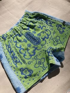 a green and blue towel laying on the ground