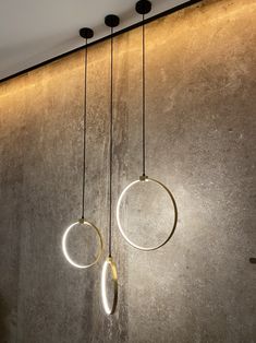 three circular lights hanging from the ceiling in a room with concrete walls and flooring