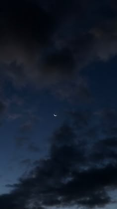 the moon is seen through some clouds in the night sky with no light on it