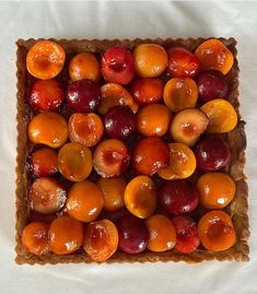 a square pastry topped with cherries and oranges